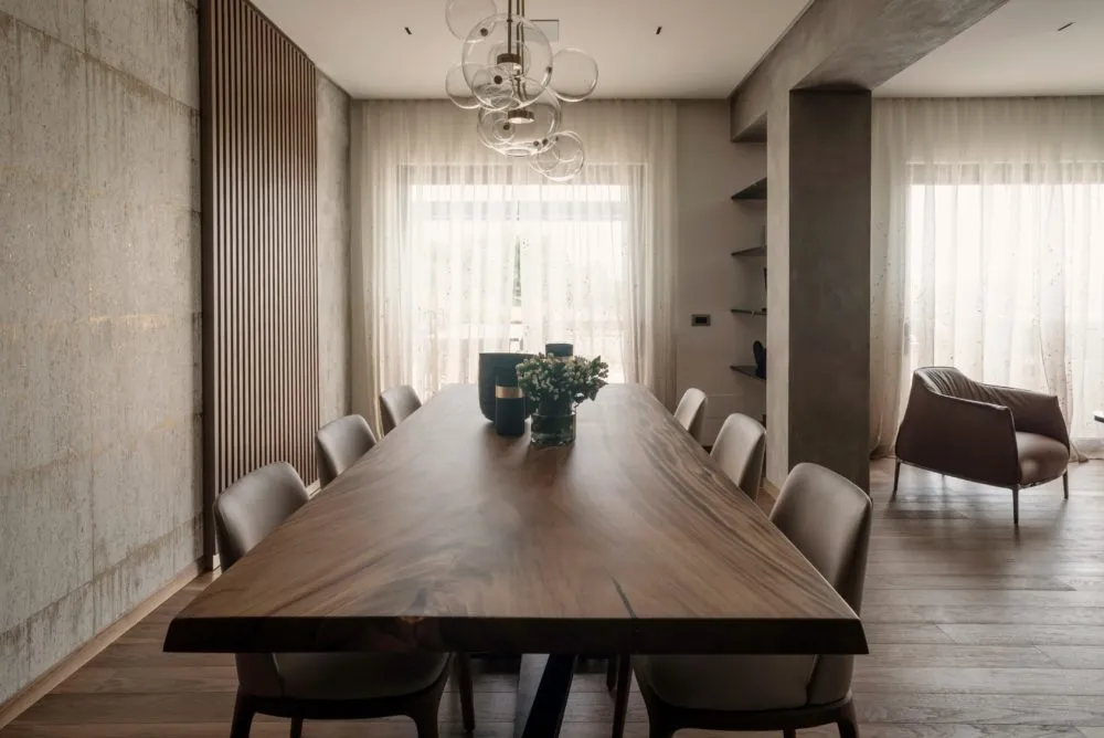 Dining area with light wooden table and decorative arched wall